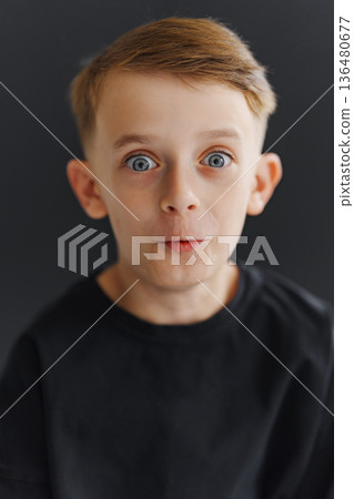 Boy with wide eyes making a surprised expression in a studio setting 136480677