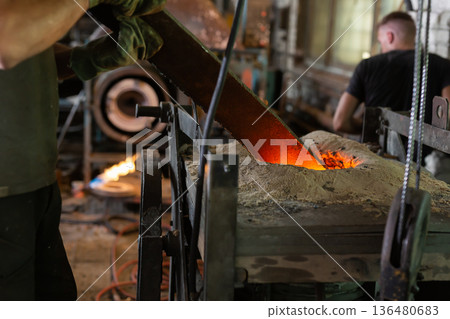 Foundry - ferrous metal is melted in an induction furnace of metallurgical plant 136480683