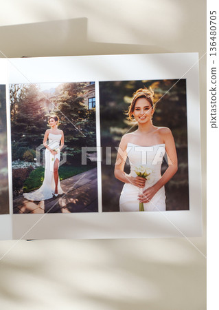 page of an open photo book with wedding photos on a white table 136480705