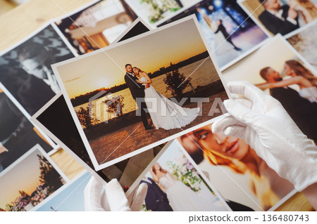 hands in white gloves and Beautiful printed wedding photos. hands in white gloves and Beautiful printed wedding photos. 136480743