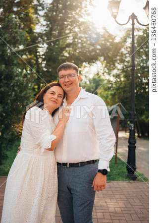 Couple enjoying a sunny day in a park setting Couple enjoying a sunny day in a park setting 136480768