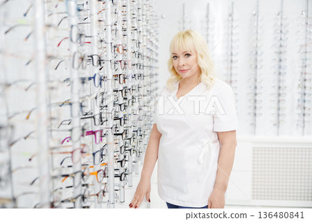 Ophthalmologist assists customers at eyewear store Ophthalmologist assists customers at eyewear store 136480841