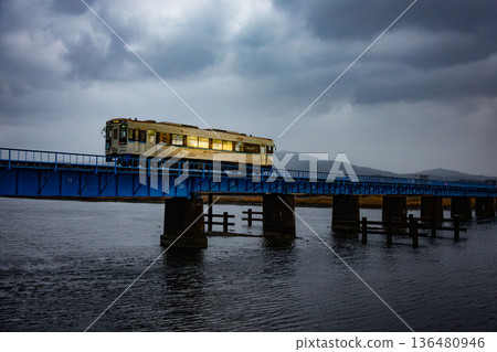 雨後，一列當地火車駛過鐵路橋。 136480946