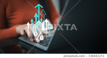Business woman using laptop with virtual rising arrows and percentage icon, depicting interest rate increase, financial growth, investment profit, and economic success in digital marketing trend. Business woman using laptop with virtual rising arrows and percentage icon, depicting interest rate increase, financial growth, investment profit, and economic success in digital marketing trend. 136481251