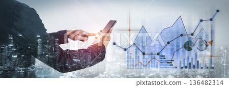 Business professional using smartphone to analyze financial data with futuristic graphics and city skyline as background in modern urban setting Scalp 136482314