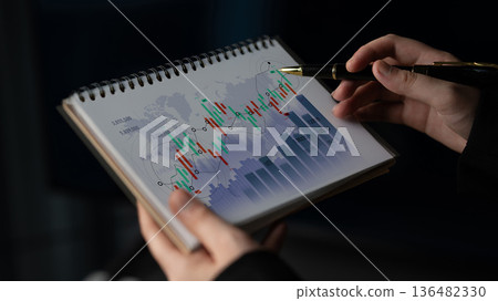Detailed Analysis of Financial Trends Through Charts and Graphs Showcased on Notebook with a Person Using a Pen for Notation Scalp 136482330