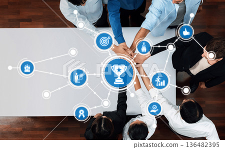 Teamwork and collaboration concept illustrating achievement and success with diverse individuals connecting through digital icons on a modern table. Amity Teamwork and collaboration concept illustrating achievement and success with diverse individuals connecting through digital icons on a modern table. Amity 136482395