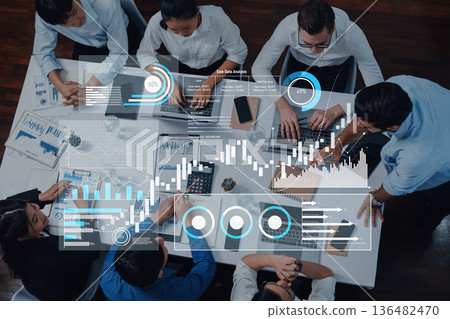 High Angle View of Diverse Business Team Analyzing Data with Laptops and Graphs in Modern Office Environment for Strategic Decision Making Trope High Angle View of Diverse Business Team Analyzing Data with Laptops and Graphs in Modern Office Environment for Strategic Decision Making Trope 136482470