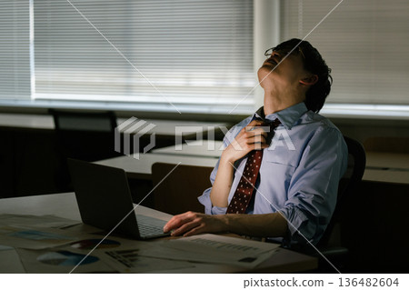 Businessman feeling tired after working overtime Businessman feeling tired after working overtime 136482604
