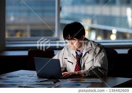 一名身穿工作服的男子正在加班 136482609