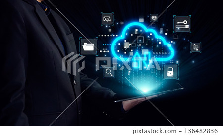 Businessman in Suit Holding Tablet with Cloud Technology Interface and Data Exchange Icons in Digital Space, Representing Innovation and Connectivity. Qubit Businessman in Suit Holding Tablet with Cloud Technology Interface and Data Exchange Icons in Digital Space, Representing Innovation and Connectivity. Qubit 136482836