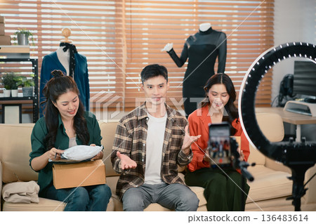 Three fashion designer using mobile phone receiving purchase order and showing talking recording video live streaming online, online market delivery concept. Three fashion designer using mobile phone receiving purchase order and showing talking recording video live streaming online, online market delivery concept. 136483614