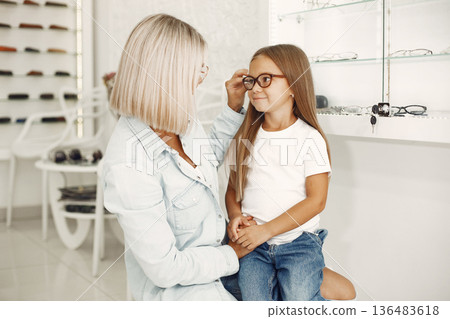 Mother with daughter. People in the store. Child in a white t-shirt. Mother with daughter. People in the store. Child in a white t-shirt. 136483618