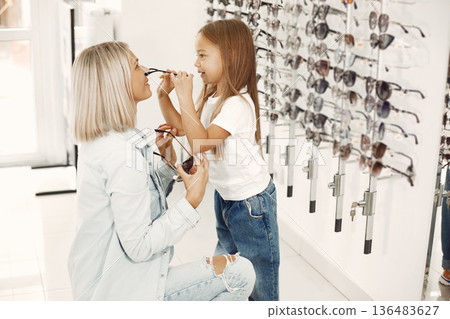 Mother with daughter. People in the store. Child in a white t-shirt. 136483627
