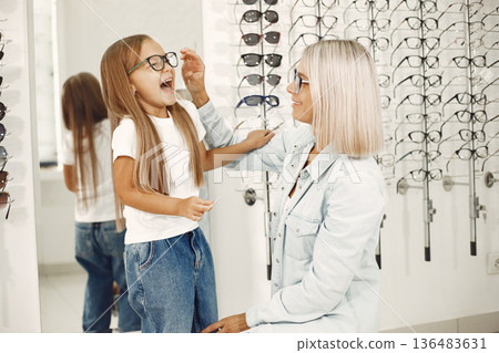 Mother with daughter. People in the store. Child in a white t-shirt. Mother with daughter. People in the store. Child in a white t-shirt. 136483631