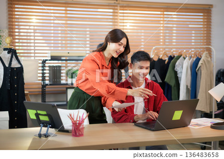 Two creative people in smart casual wear discussing business brainstorming meeting ideas with laptop design project 136483658