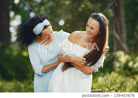 Women in a summer forest. Lady in a blue dress. Family posing and embracing. 136483676