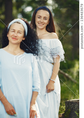 Women in a summer forest. Lady in a blue dress. Family posing and embracing. 136483679