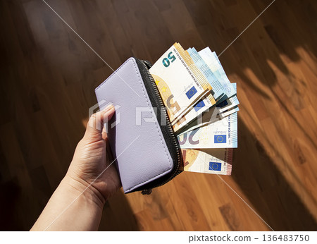 Leather wallet opened to reveal euro currency. Finance, budgeting, and careful money management. Leather wallet opened to reveal euro currency. Finance, budgeting, and careful money management. 136483750