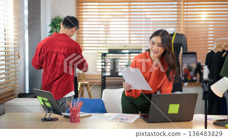 Online seller setting up fashion product and workspace at home studio, preparing for live streaming sales Online seller setting up fashion product and workspace at home studio, preparing for live streaming sales 136483829