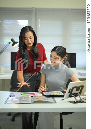 A colleague team in a creative brainstorming session on design colour and analyzing colorful charts and drafts A colleague team in a creative brainstorming session on design colour and analyzing colorful charts and drafts 136483850