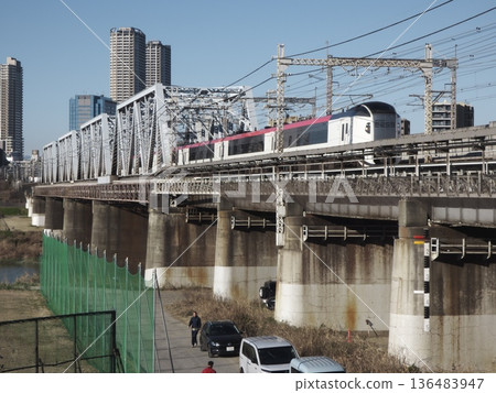 The Narita Express E239 series crossing the Tamagawa Bridge and the buildings of Musashi-Kosugi The Narita Express E239 series crossing the Tamagawa Bridge and the buildings of Musashi-Kosugi 136483947