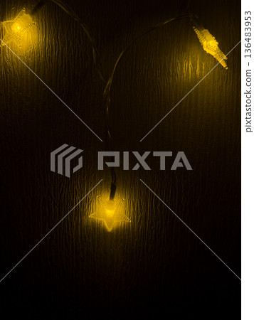 Warm festive stars lighting up a dark room Warm festive stars lighting up a dark room 136483953