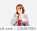 Happy woman talking on phone and holding coffee cup 136483965