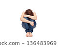 Depressed woman sitting on floor hugging knees isolated on white background 136483969