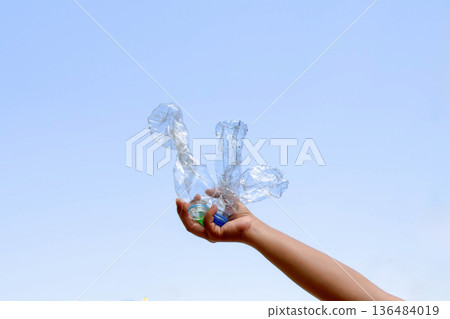 Holding a piece of plastic bottle for recycling conveys the concept of environmental protection and eco-friendliness. Holding a piece of plastic bottle for recycling conveys the concept of environmental protection and eco-friendliness. 136484019