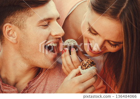 Smiling couple feeding each other. Smiling couple feeding each other. 136484066