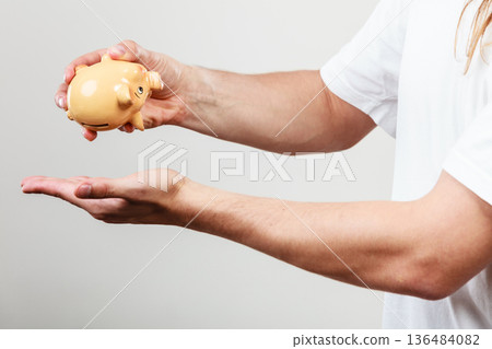 Male hands with coins and piggybank Male hands with coins and piggybank 136484082