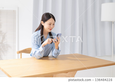 Woman operating a smartphone 136484228