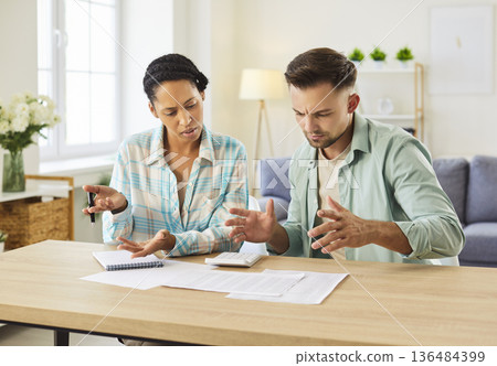 Worried couple analyzing bills and household budget at home 136484399