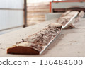 The wooden board is cut on the machine. Sawing wood. Wood processing workshop. 136484600