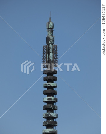 Close-up of the traditional spire that adorns the top of a temple tower against blue sky Close-up of the traditional spire that adorns the top of a temple tower against blue sky 136485137
