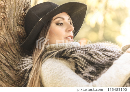 Beautiful autumnal woman in park 136485190