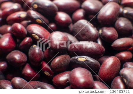 A close-up of a large amount of red kidney beans in a clear storage jar. Macro shot of the beans with a shallow depth of field. A close-up of a large amount of red kidney beans in a clear storage jar. Macro shot of the beans with a shallow depth of field. 136485731
