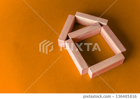 A metaphorical model of a wooden house on a colored background with copy space. Housing and real estate concept A metaphorical model of a wooden house on a colored background with copy space. Housing and real estate concept 136485816