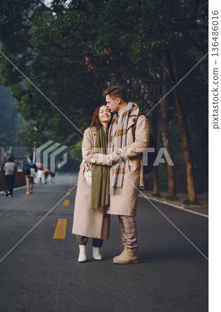 newlywed couple showing affection and holding hands as they are walking through the zhangjiajie national forest park in China. 136486016