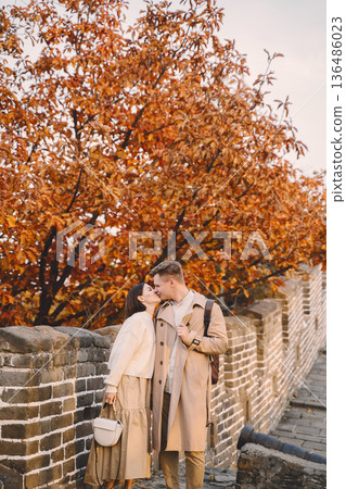 young couple kissing at the Great Wall of China. Newly married couple on their honeymoon to the Great Wall of China near Beijing China. young couple kissing at the Great Wall of China. Newly married couple on their honeymoon to the Great Wall of China near Beijing China. 136486023