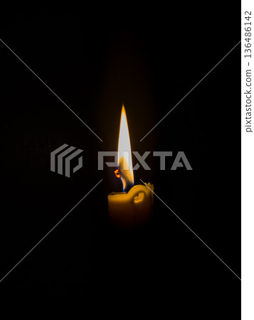 Single candle light in darkness Single candle light in darkness 136486142