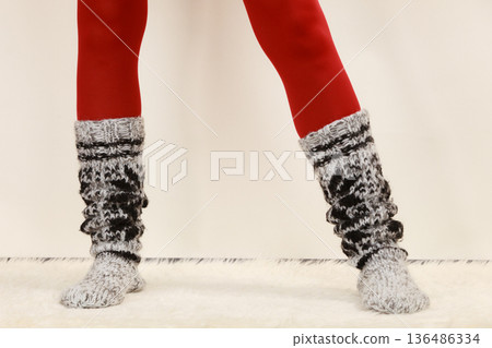 Woman legs wearing woolen socks and red tights 136486334
