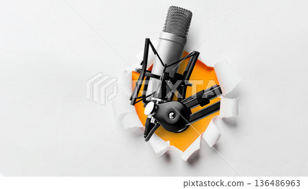 Podcast microphone breaks through a heart-shaped hole on a white background 136486963