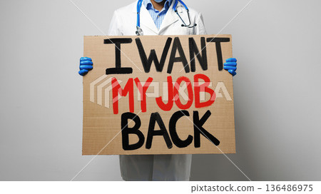 Doctor holding a sign asking to get job back in protest during work hours 136486975