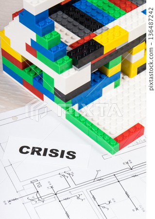 Electrical diagrams of house with building under construction made of blocks and inscription crisis 136487242