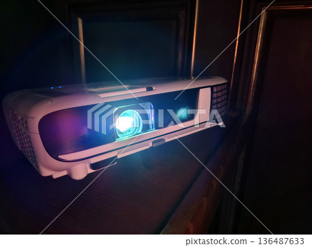 Cinema hall. Projector lens in operation. Movie is shown through projector Cinema hall. Projector lens in operation. Movie is shown through projector 136487633