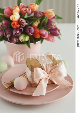 Easter Table Setting with Gift Box, Decorated Eggs and Tulips. Festive Spring Lifestyle Easter Table Setting with Gift Box, Decorated Eggs and Tulips. Festive Spring Lifestyle 136487765
