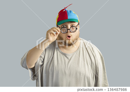 Surprised overweight man in colorful propeller cap and round glasses, comic Surprised overweight man in colorful propeller cap and round glasses, comic 136487986