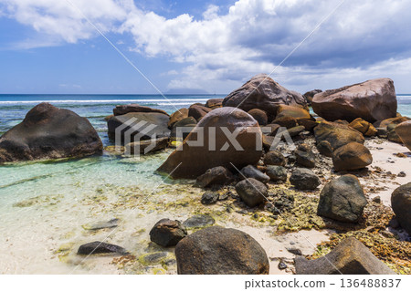 Coastal landscape, wet stones laying on white sands Coastal landscape, wet stones laying on white sands 136488837